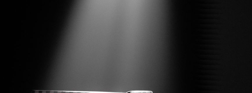 minimalistic spotlight on black chair in dark room